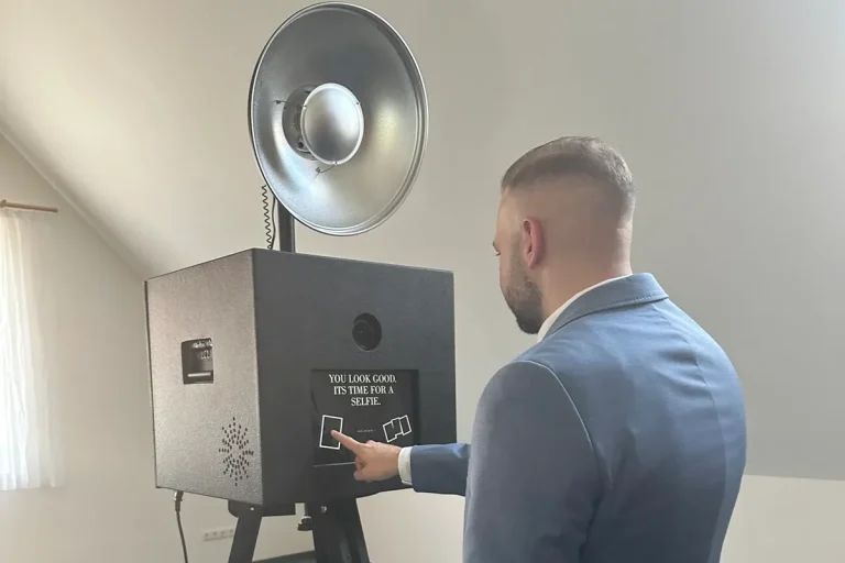 Person bedient Fotobox mit Touchscreen Person klickt auf den Touchscreen der Fotobox, um eine Aufnahme zu starten, ideal für interaktive Nutzung auf Events und Feiern.