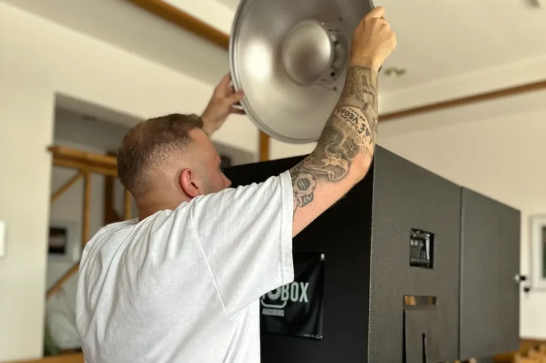 Mitarbeiter beim Aufbau der Fotobox Mitarbeiter stellt die Fotobox ein und bereitet sie für den Einsatz auf einer Veranstaltung vor.