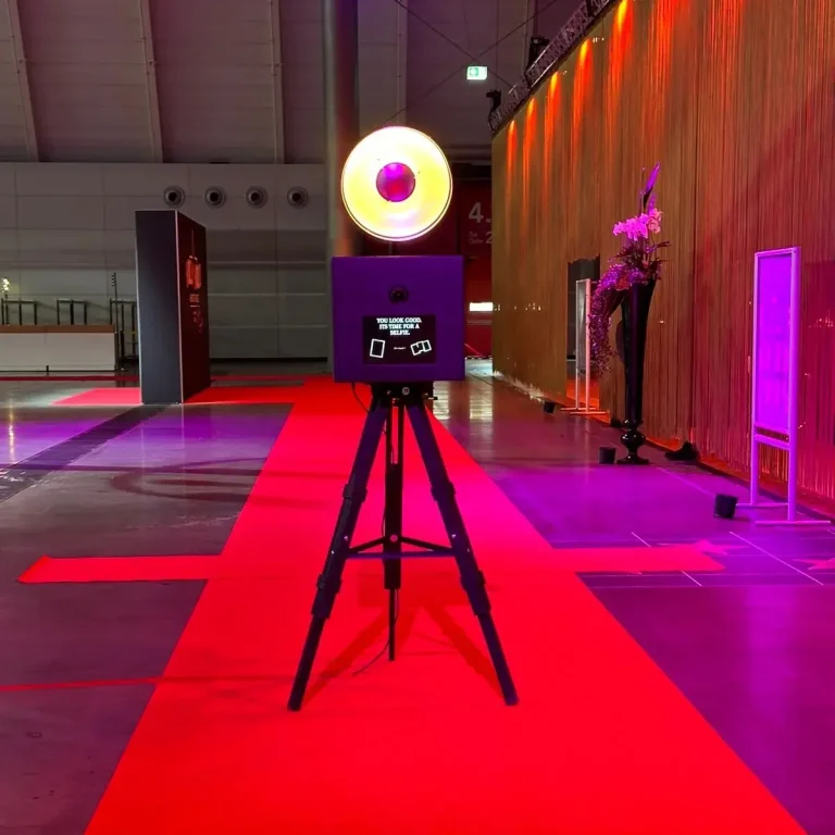 Fotobox auf rotem Teppich bei exklusivem Event Schwarze Fotobox steht auf rotem Teppich, perfekt in Szene gesetzt für elegante Veranstaltungen.